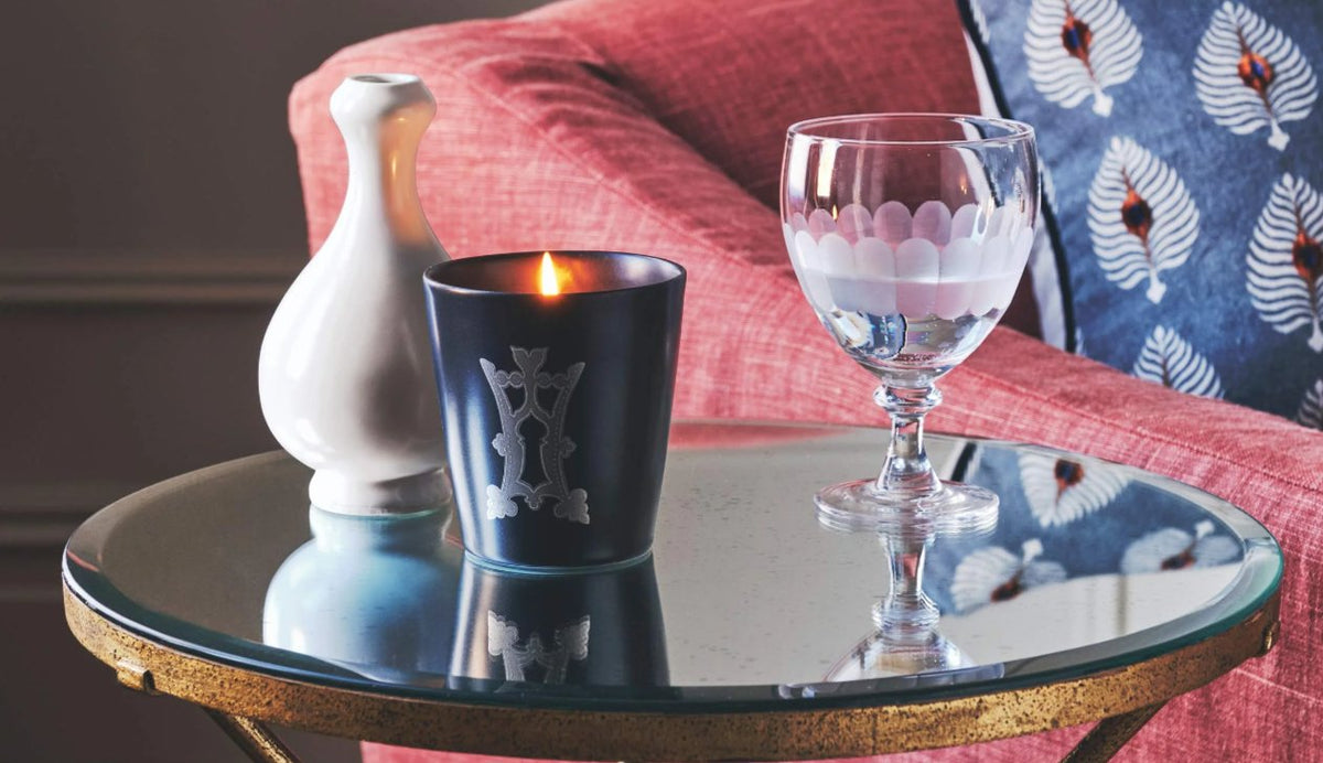 Wine glass and carafe beside a sofa