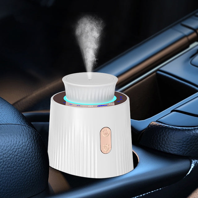 Car diffuser in action, fitting into a car's cup holder, with visible steam and a glowing blue ring indicator.