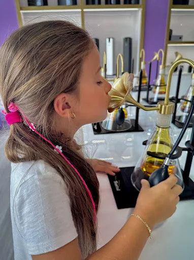 Founder’s daughter smelling an Aromely fragrance oil in the Aromely showroom.