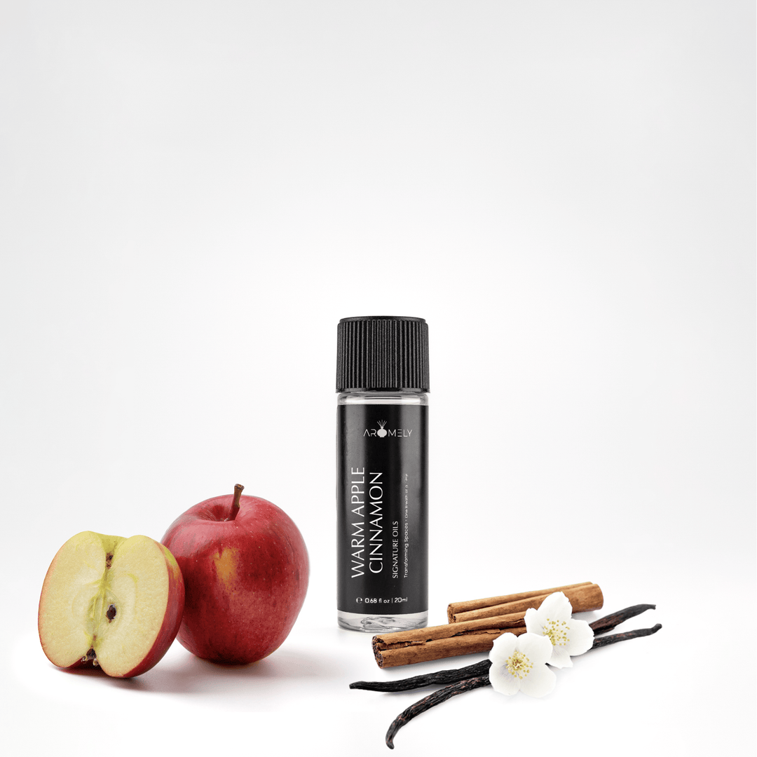 Aromely Warm Apple Cinnamon essential oil blend, 20ml bottle, with red apples, cinnamon sticks, vanilla, and delicate white blossoms. A cozy, spiced fragrance perfect for fall and winter—evoking the warmth of an upscale ski lodge.