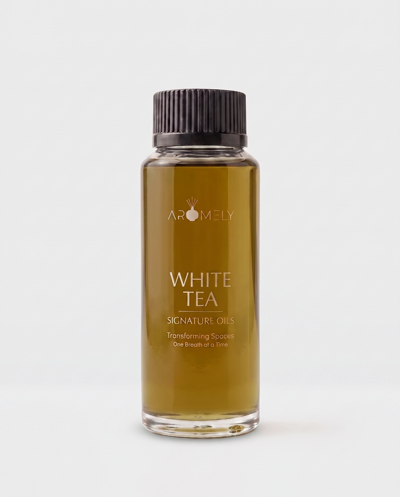 Aromely White Tea Signature Oils in a clear glass bottle with a black ribbed cap, containing an amber-colored oil, on a light gray background.