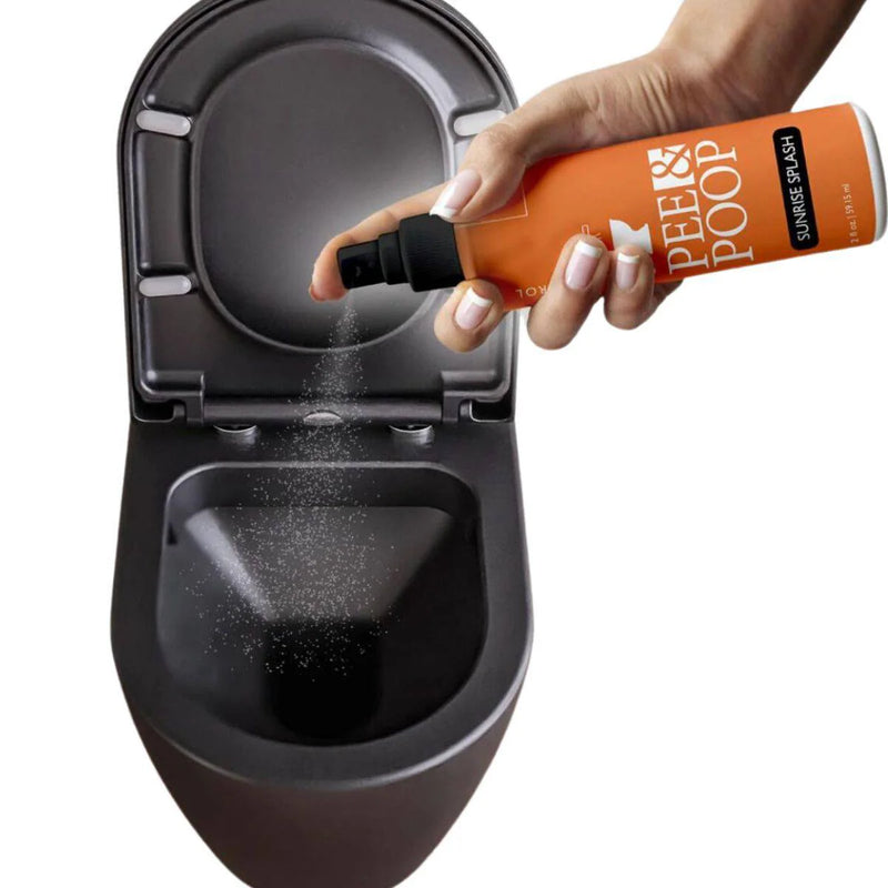 Hand spraying Aromely Pee & Poop Sunrise Splash toilet odor spray into toilet bowl before use
