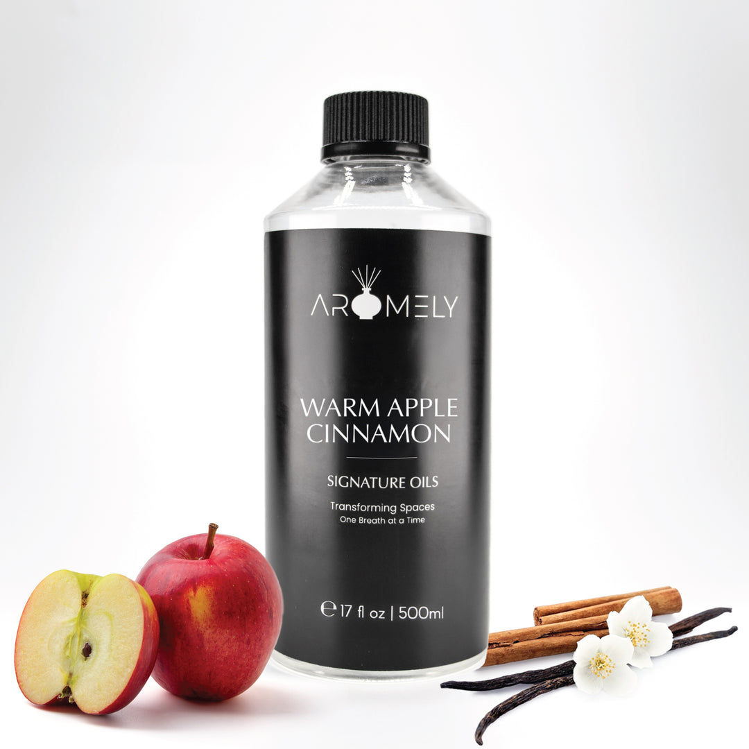 Aromely Warm Apple Cinnamon diffuser oil, 500ml bottle, with red apples, cinnamon sticks, vanilla, and delicate white blossoms. A cozy, spiced fragrance perfect for fall and winter—evoking the warmth of an upscale ski lodge.