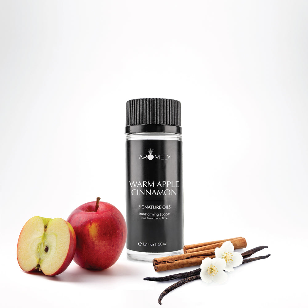 Aromely Warm Apple Cinnamon diffuser oil, 50ml black bottle, with red apples, cinnamon sticks, vanilla, and delicate white blossoms. A cozy, spiced fragrance perfect for fall and winter.